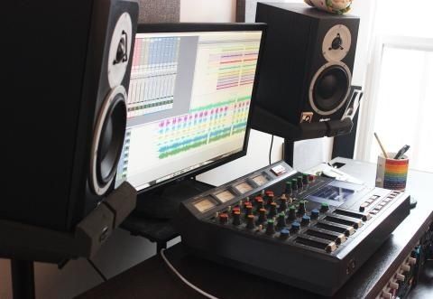 Studio d’enregistrement avec console de mixage et écran audio